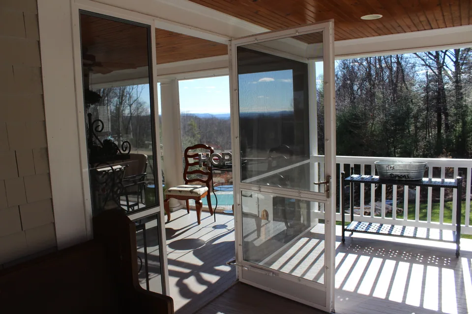 Three-season porch with tempered glass inserts fitted into screen wall panels