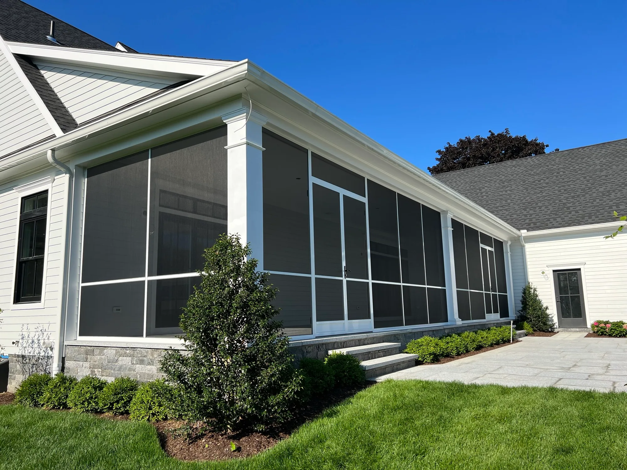 Enclosed porch with screen wall panels and a screen door